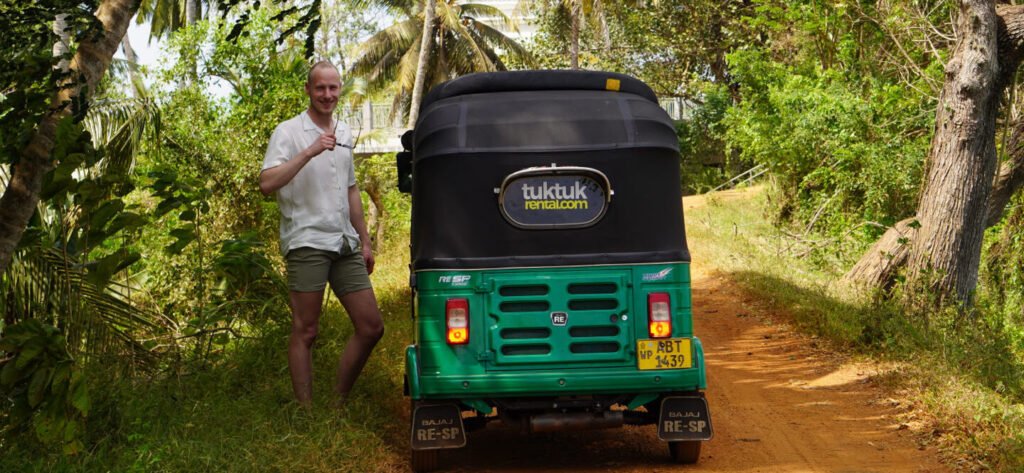 Julian bij de tuktuk op een zandpad tussen de palmen bij Chilaw