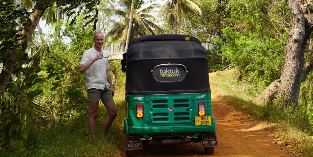 Julian bij de tuktuk op een zandpad tussen de palmen bij Chilaw