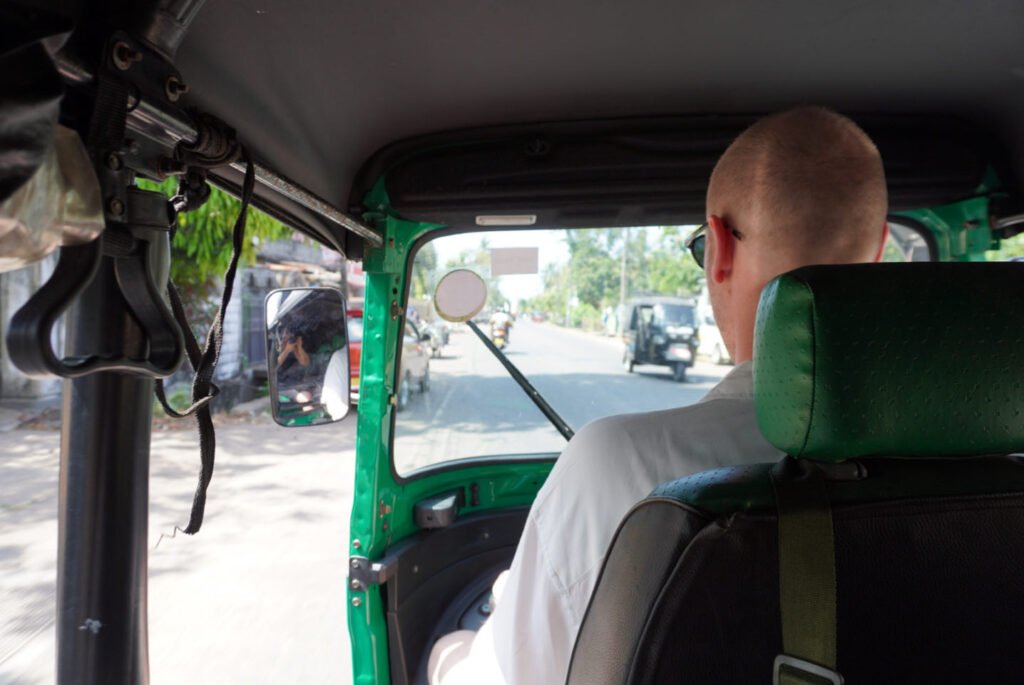 chilaw -  julian rijdt tuktuk achteraanzicht
