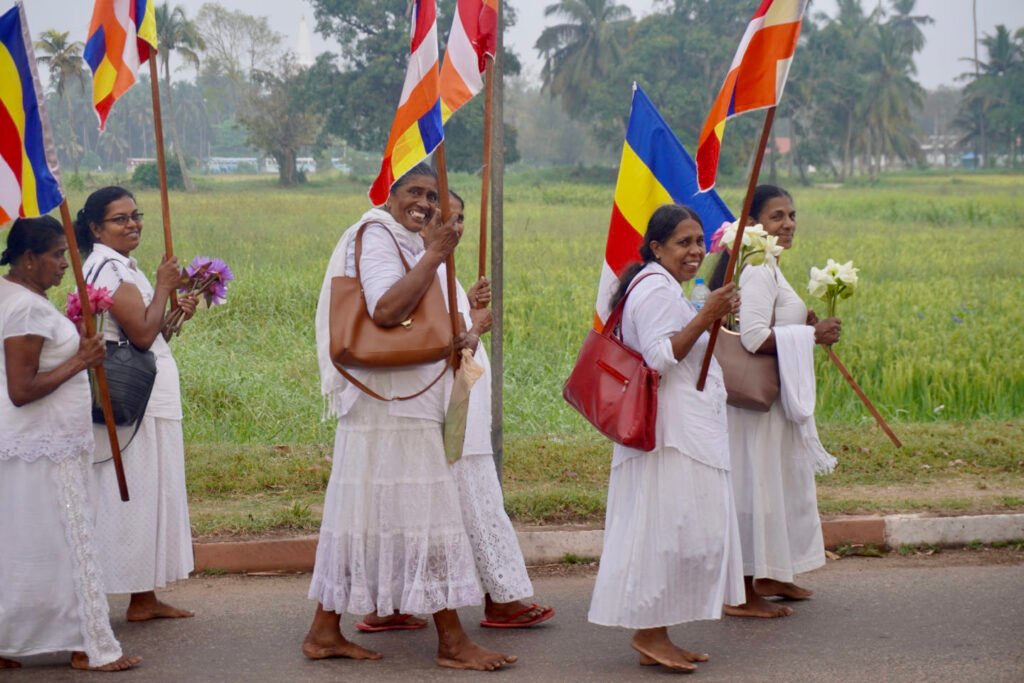 Pelgrims in het wit met boeddhistische vlaggen in Anuradhapura