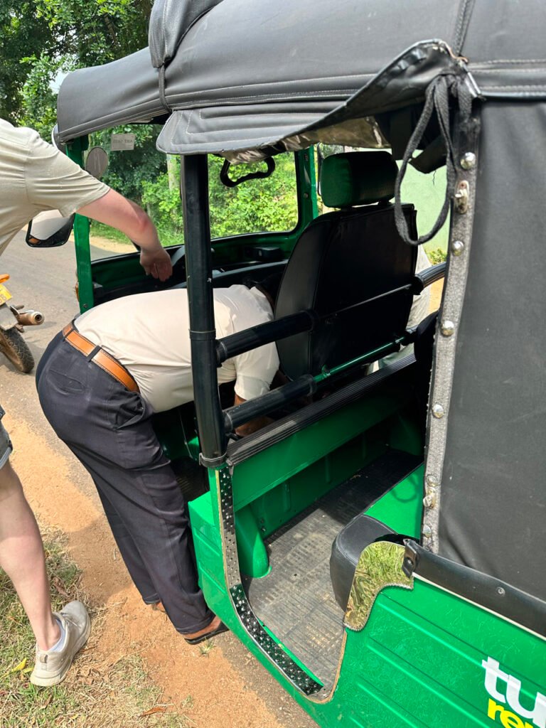 Een local helpt met de tuktuk die stilviel bij Anuradhapura