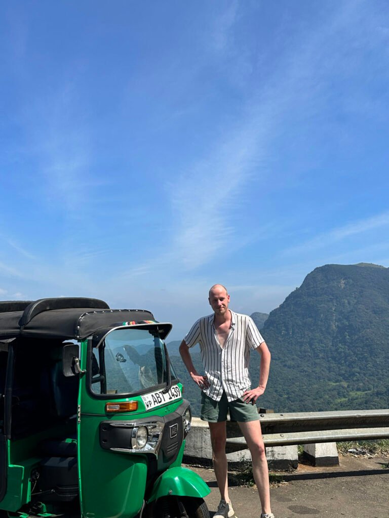 Julian bij de tuktuk op een uitzichtpunt langs de 18-bend road