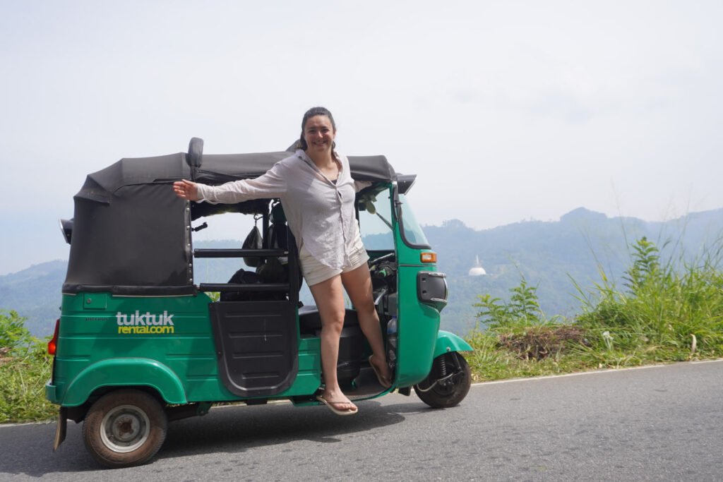 Mit dem Tuk-Tuk durch Sri Lanka: unsere Route in 4 Wochen Florine poseert op de tuktuk langs een bergweg richting Hatton