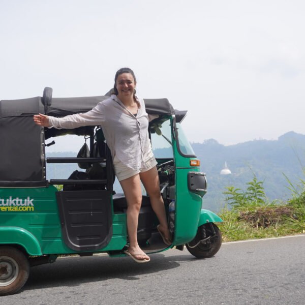 Florine poseert op de tuktuk langs een bergweg richting Hatton