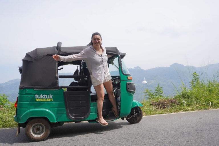 Florine poseert op de tuktuk langs een bergweg richting Hatton