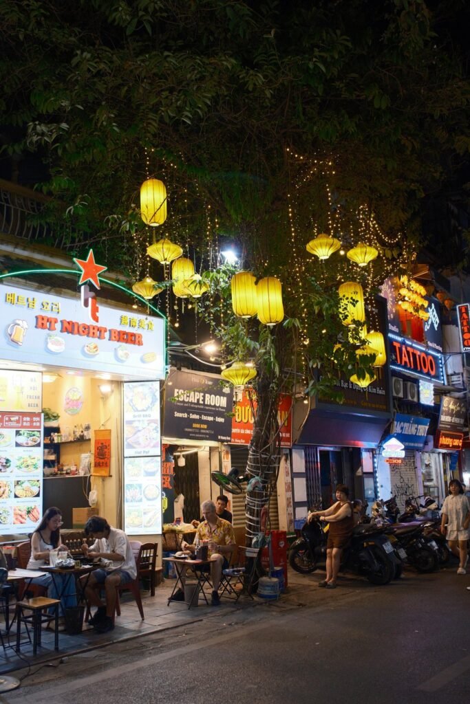 Straat met gele lampions en terrasjes in de Old Quarter van Hanoi bij avond